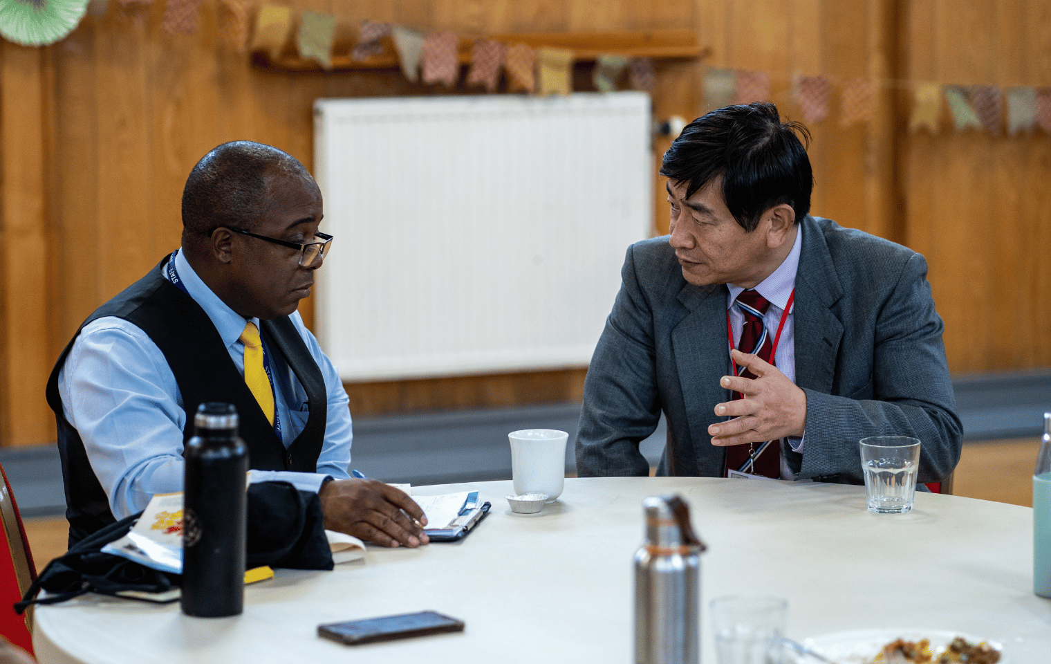 Two men sat at a table in conversation