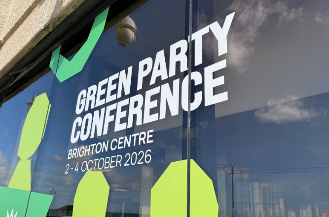 A conference centre glass window reads 'Green Party Conference 2 - 4 October 2026